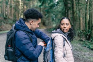 Two people with backpacks in the forest.