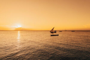 A silhouette of a sailing boat while the sun goes down