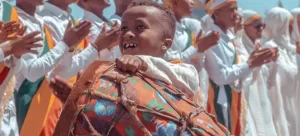 A child holding a drum at a festival in Ethiopia