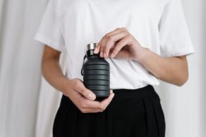 A person holding a reusable water bottle for eco-friendly safaris.