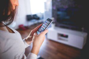 A woman holding a phone in her hands in the living room